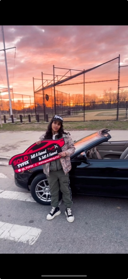 Customer collecting a convertible at sunset, holding the TyFix SOLD key