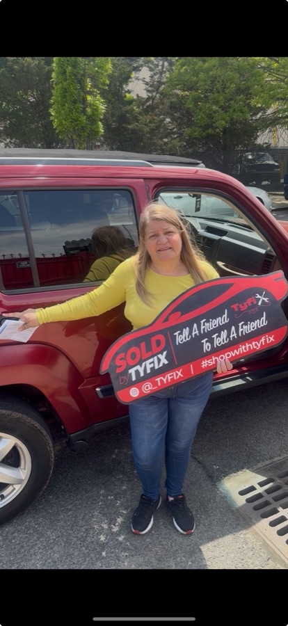 Customer collecting a red SUV, holding the TyFix SOLD key