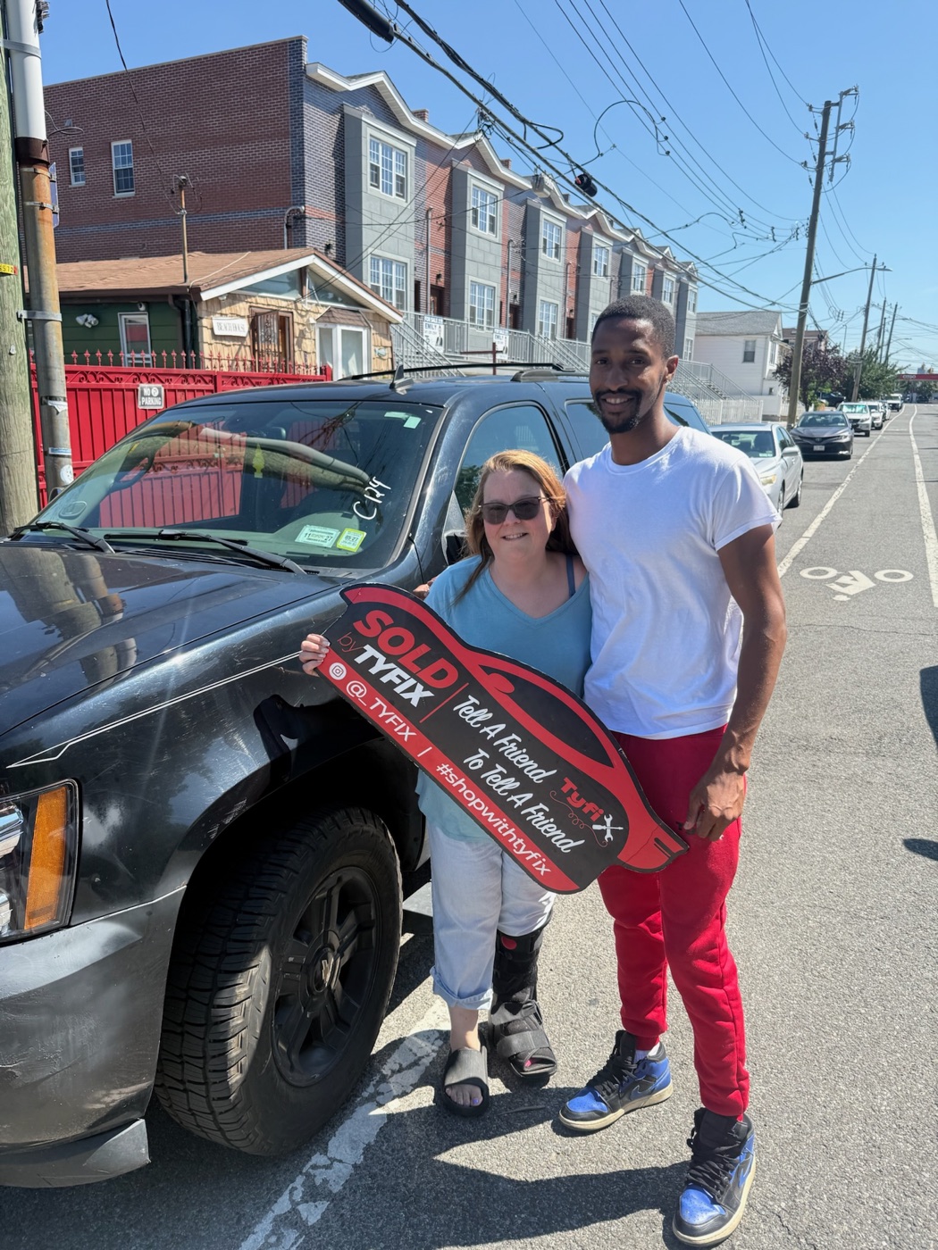 TyFix handing over a sold vehicle to a customer holding the TyFix SOLD key